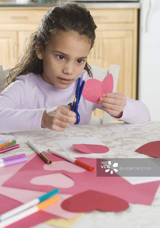 制作情人节纸质红心的年轻女孩图片素材