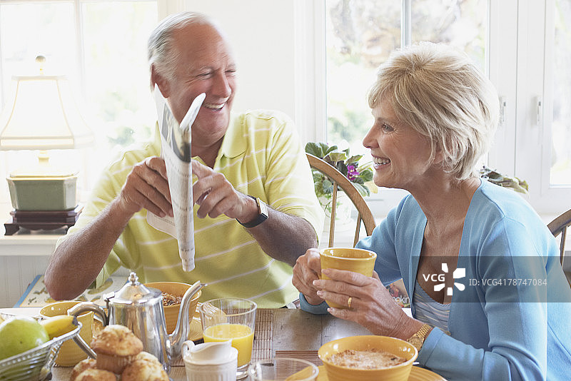 年长的夫妇在早餐时阅读报纸图片素材