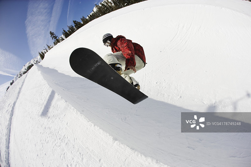 滑雪者在U型池跳跃图片素材