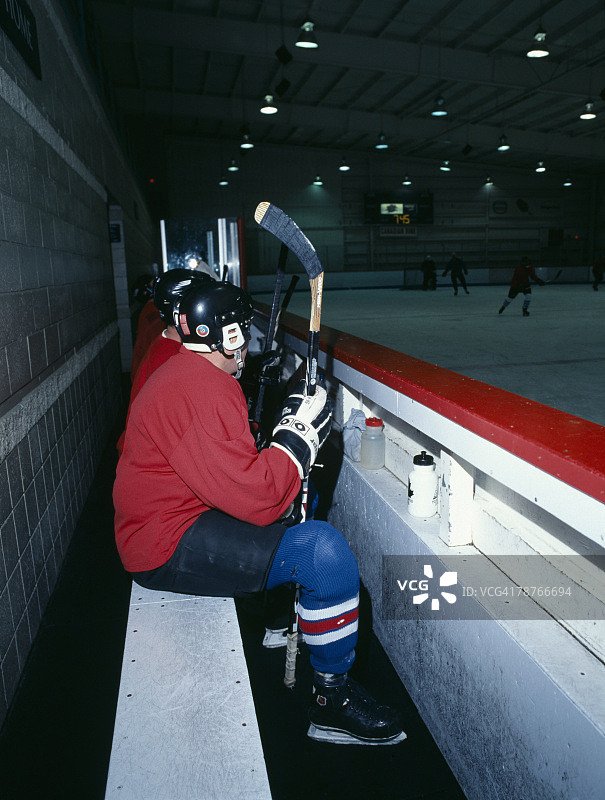 坐在长凳上的冰球运动员图片素材