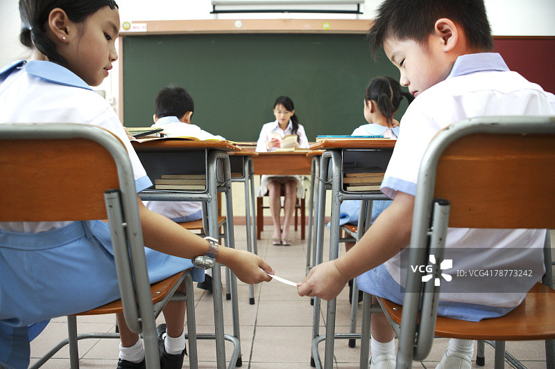 两个小学生在课堂上传纸条图片素材