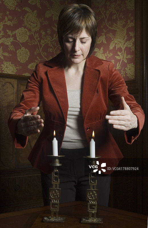 女子在安息日蜡烛前祈祷图片素材