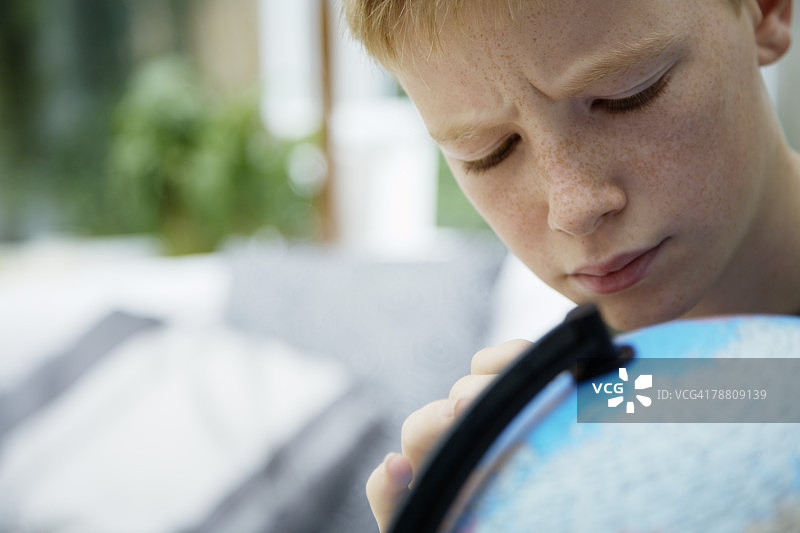 青少年男孩看着地球仪图片素材