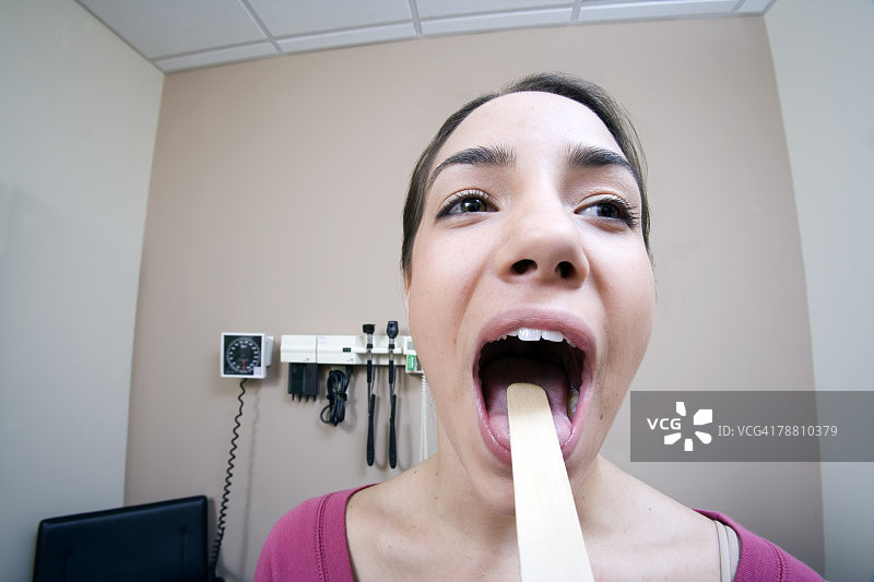 医生使用压舌板检查女人图片素材