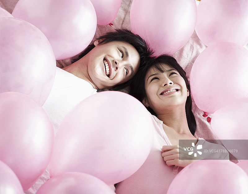 躺在粉色气球中的情侣图片素材