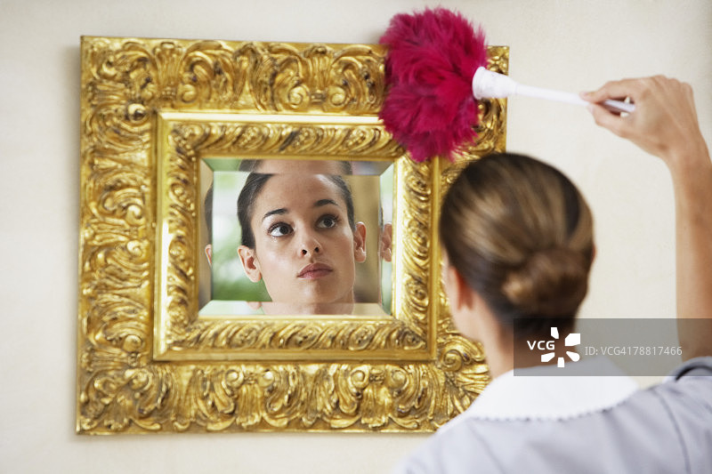 管家拿着鸡毛掸子除尘图片素材