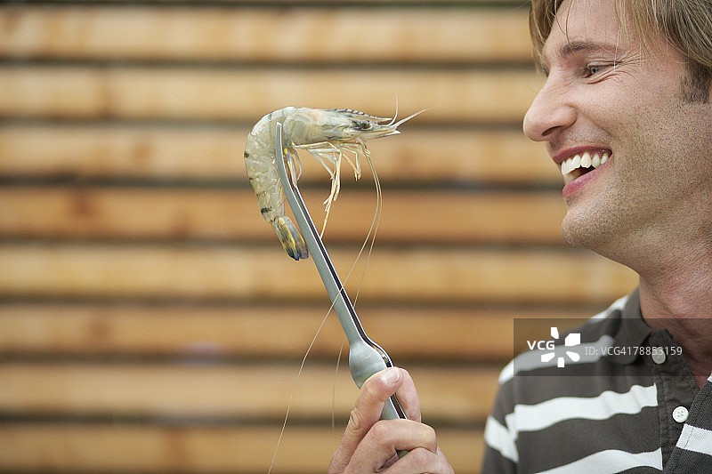 男人用夹子夹着虾图片素材