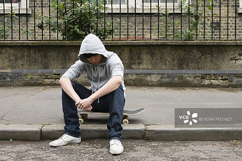坐在滑板上的年轻男人图片素材