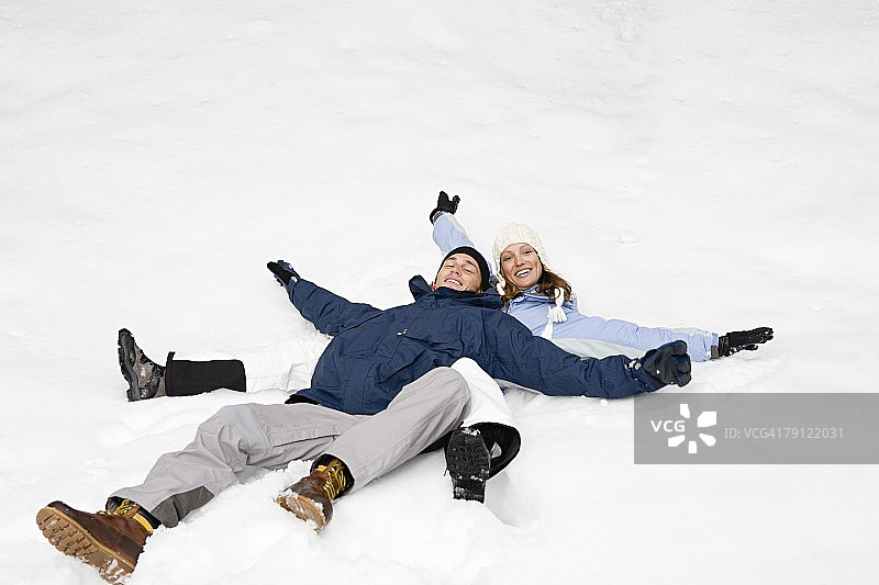 一对情侣躺在雪地里图片素材