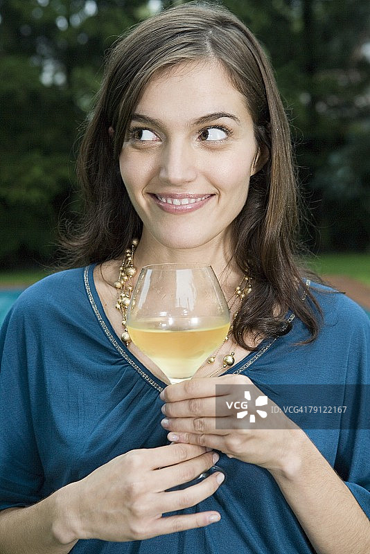 年轻女人拿着一杯葡萄酒图片素材