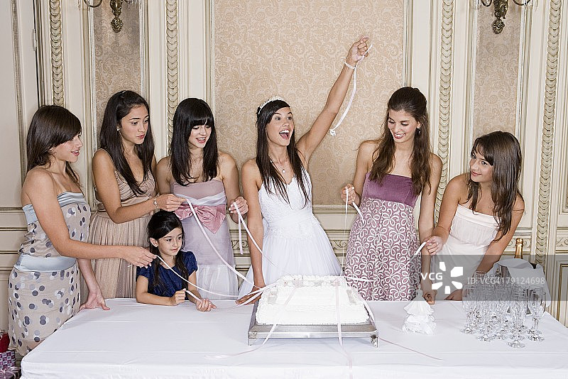 女孩们拉蛋糕上的彩带图片素材