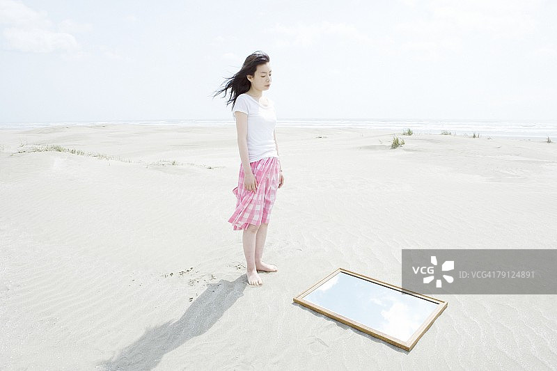 海滩边照镜子的女人图片素材
