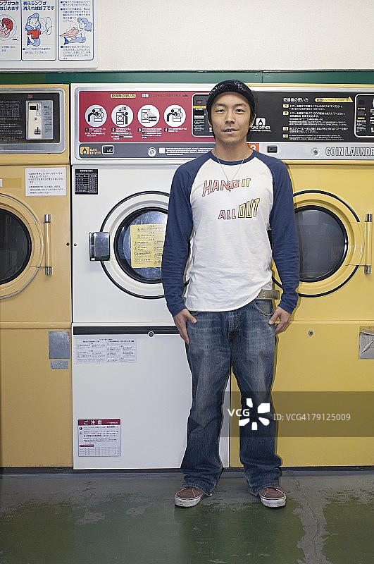 在自助洗衣店的年轻男人图片素材