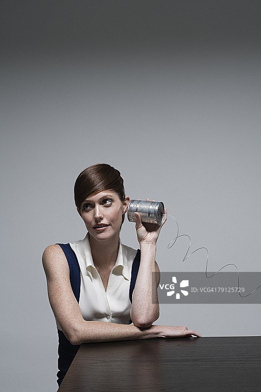 使用铁罐电话的商务女人图片素材