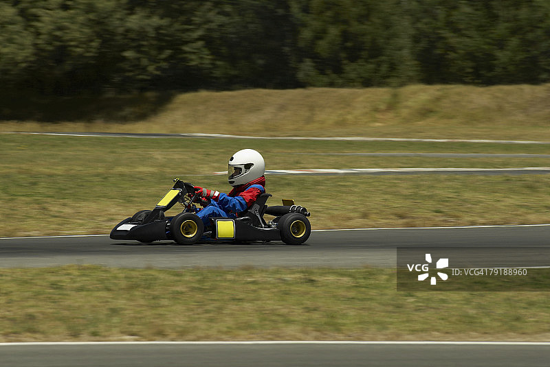 在赛车跑道上开卡丁车的人的侧面轮廓图片素材