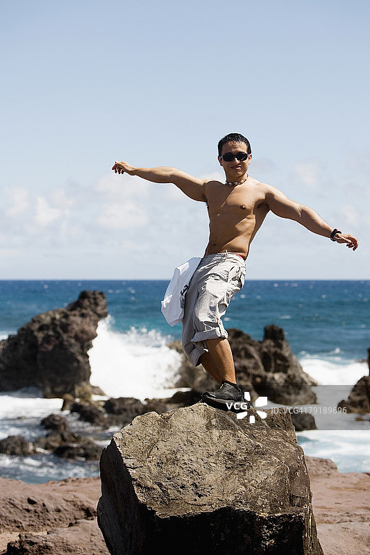 青年男人在夏威夷岩石上摆姿势图片素材