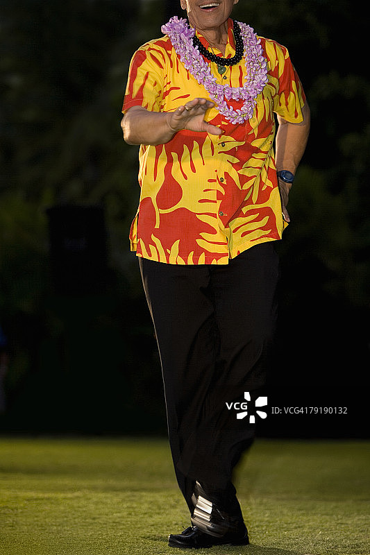 男人在檀香山威基基海滩的草坪上跳草裙舞图片素材