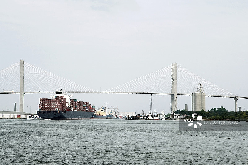 美国佐治亚州萨凡纳河上的集装箱船和塔尔马奇大桥图片素材