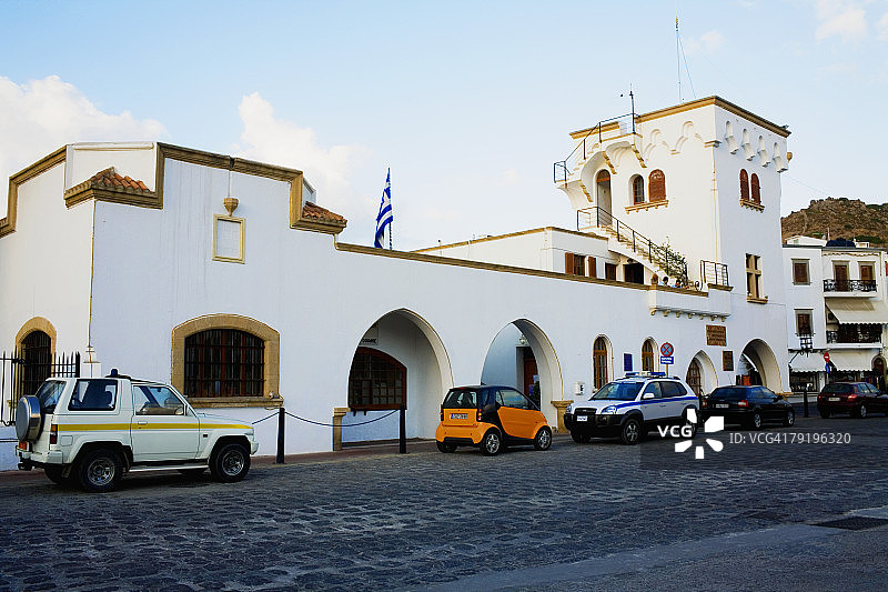 希腊帕特莫斯岛建筑前停放的汽车图片素材