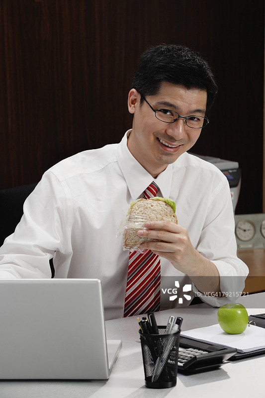 男子在办公桌前吃午饭图片素材