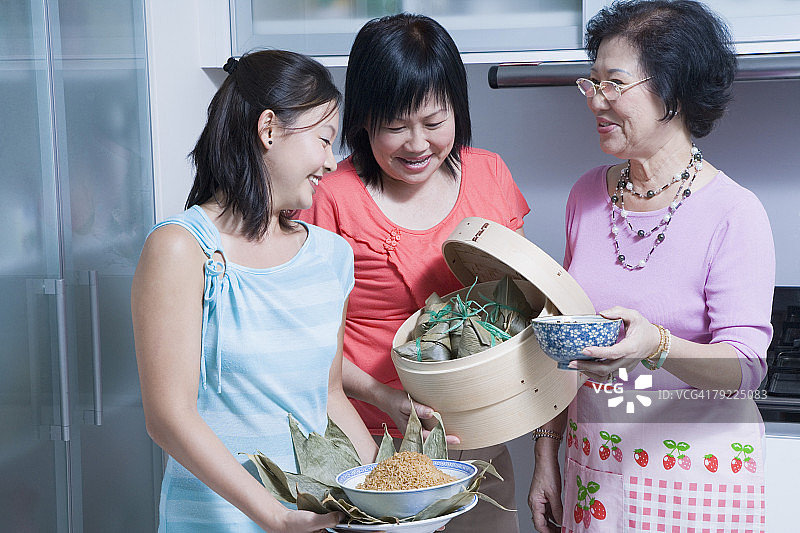 老年妇女与女儿孙女在厨房图片素材