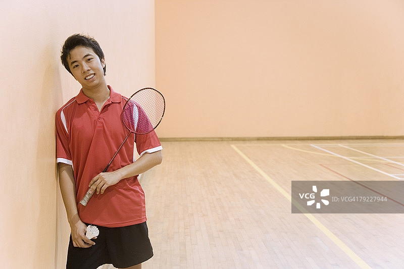 年轻男子拿着羽毛球拍和羽毛球的肖像图片素材