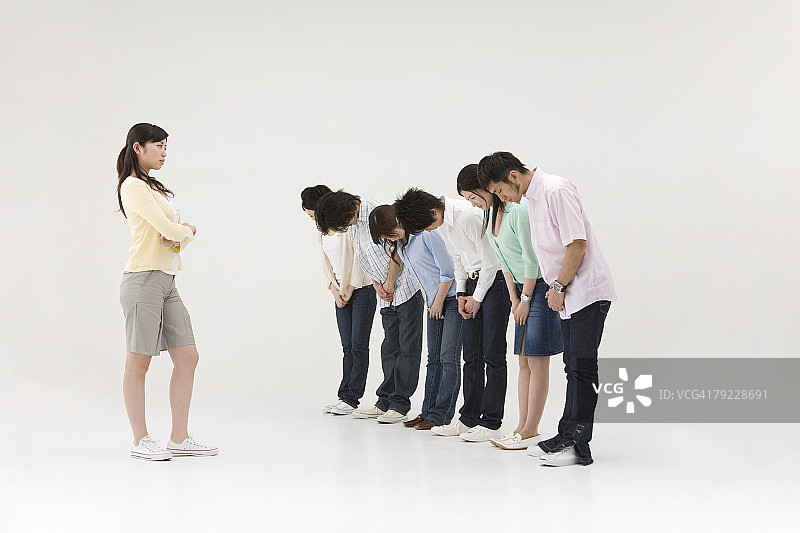 一群人向一位年轻女子鞠躬图片素材