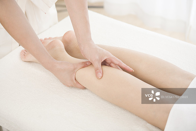 按摩治疗师进行足部按摩图片素材