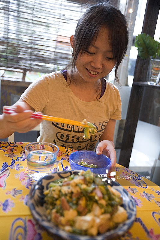 年轻女人吃炒苦瓜图片素材