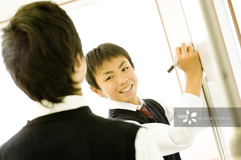 站在白板前的青少年男孩图片素材