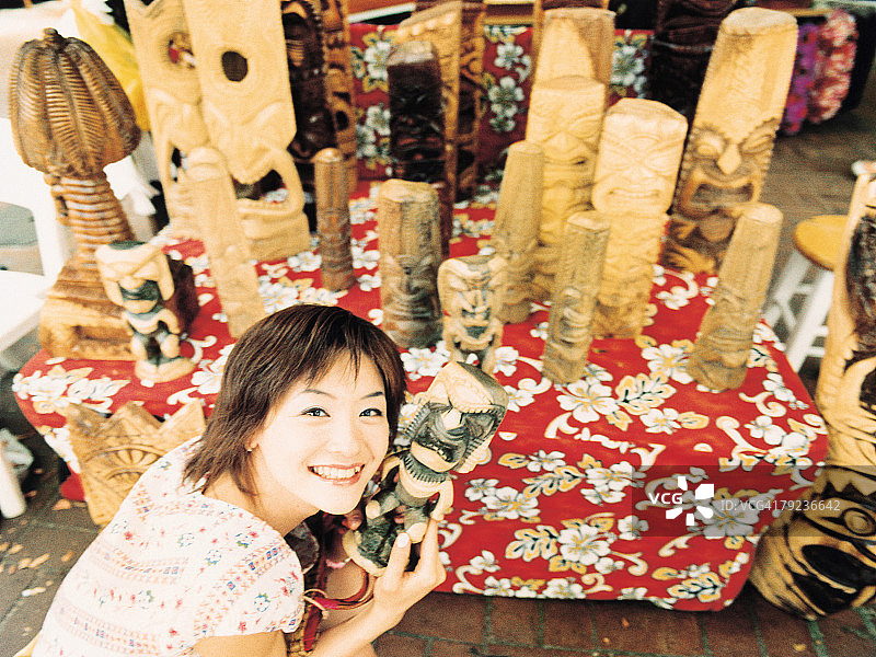 年轻女子拿着夏威夷手工艺品，微笑图片素材