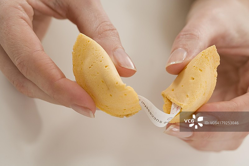 女人掰开幸运饼干图片素材