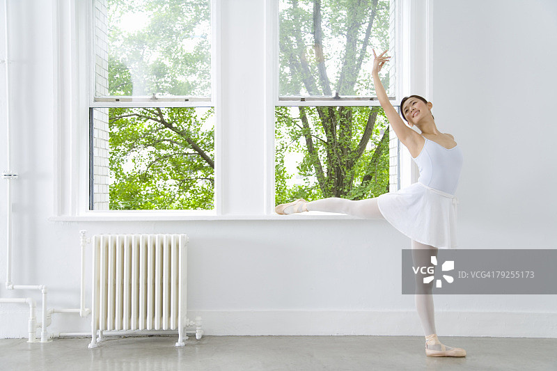 在窗边摆姿势的芭蕾舞演员图片素材