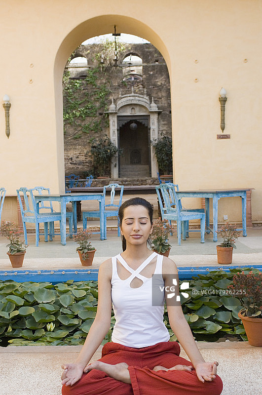 在印度拉贾斯坦邦尼姆拉纳堡以莲花姿势闭着眼睛的年轻女子图片素材