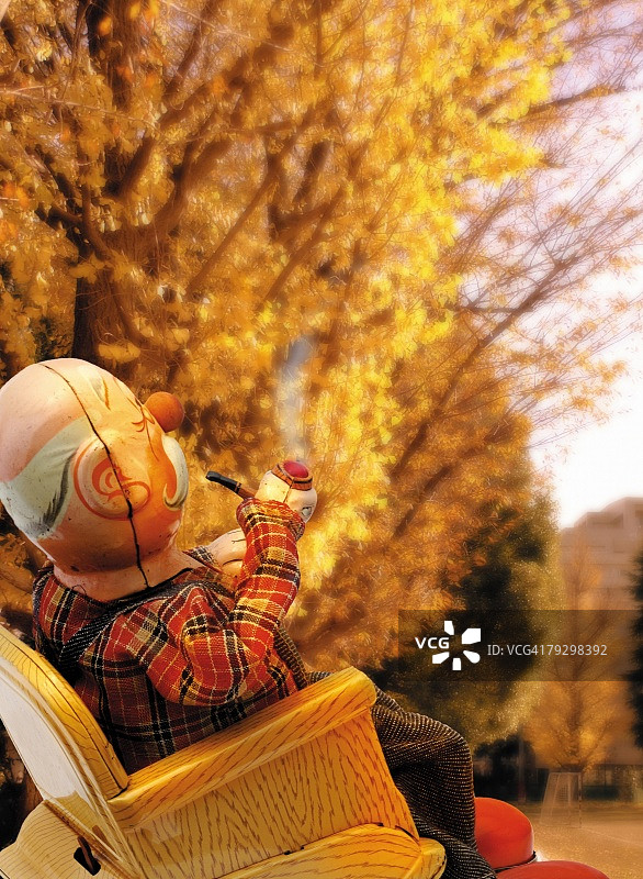 玩具娃娃：吸烟的祖父侧面照（竖版彩色摄影，景深效果）图片素材