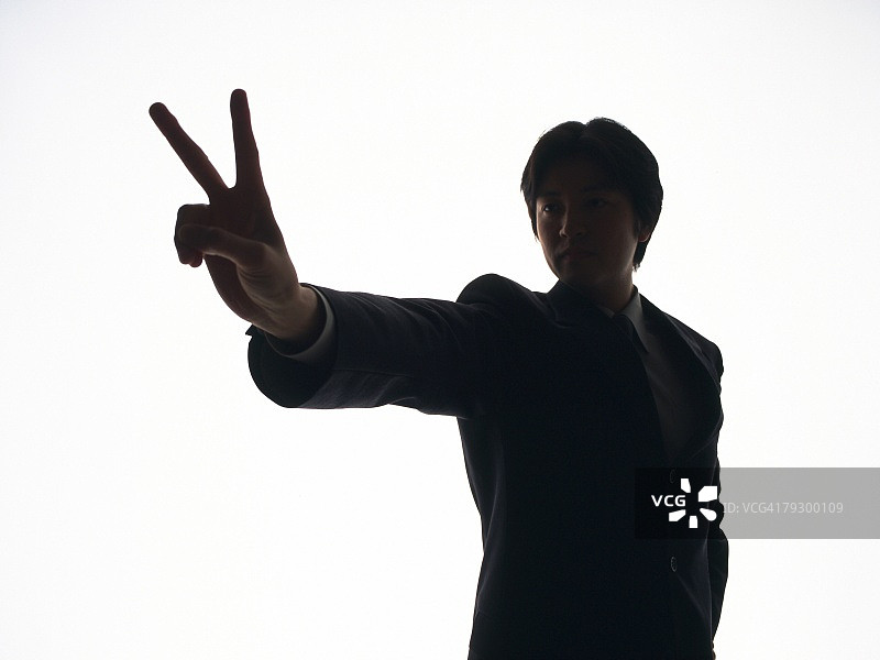 做V字手势的商人剪影图片素材