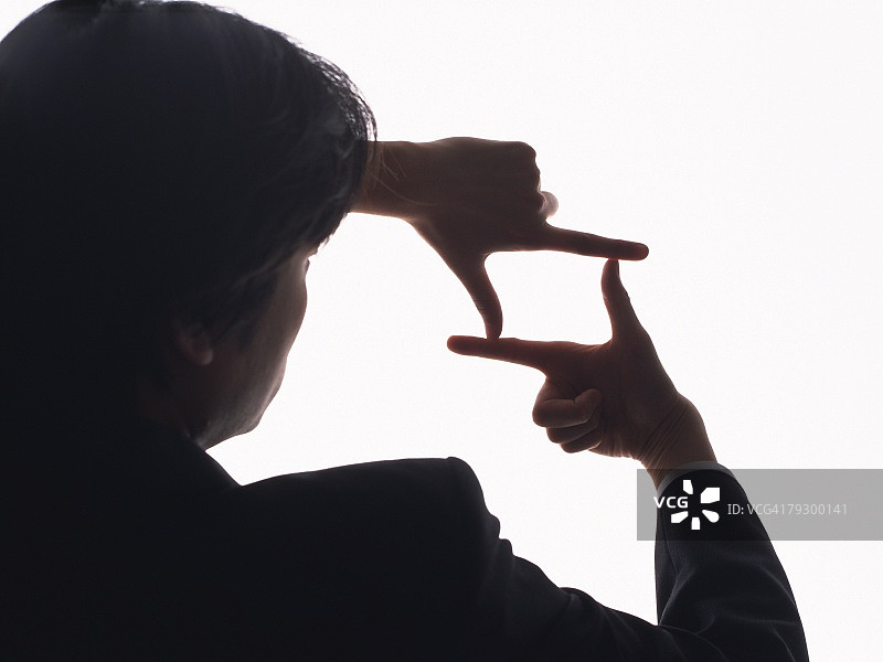 商人手指比划相框的背影剪影图片素材