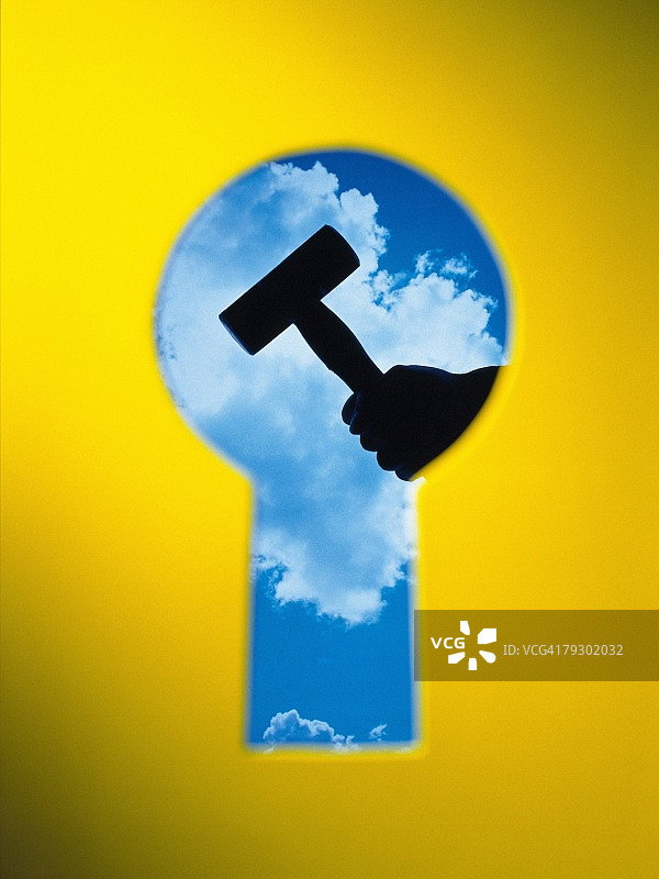 钥匙孔与持锤子的手，合成图图片素材