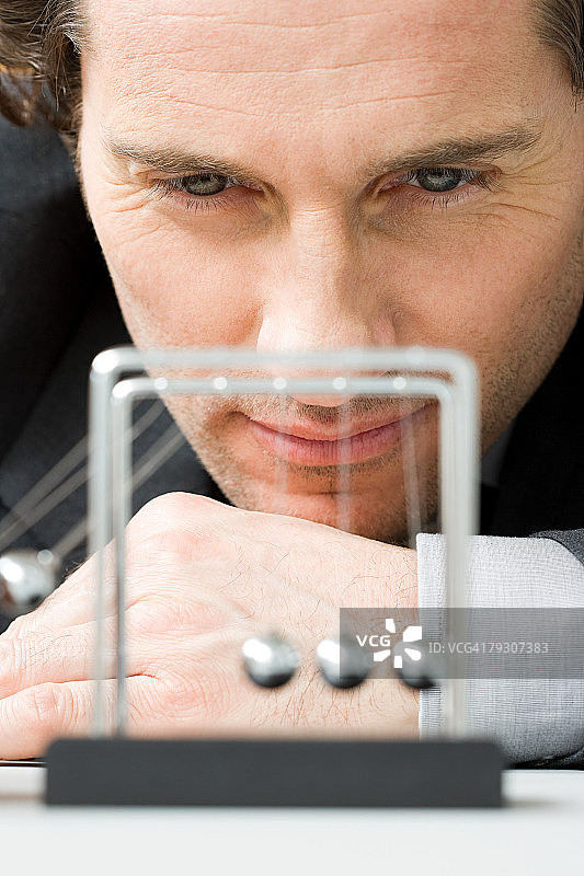 男人观看牛顿摆的运动图片素材