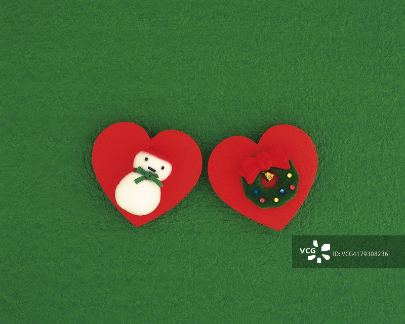 心形板上的圣诞装饰品、圣诞花环和雪人高角度视图图片素材