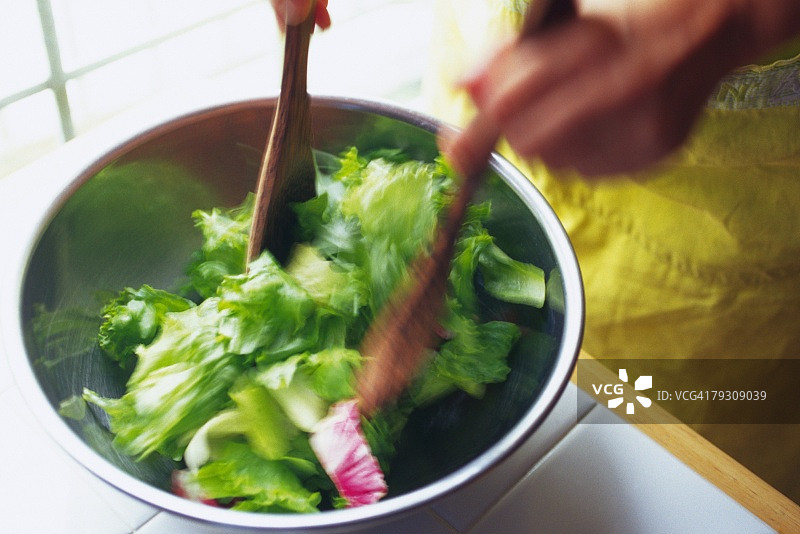 厨房工人在搅拌混合沙拉，模糊效果图片素材