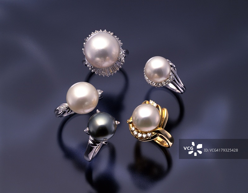 黑色背景上的五个珍珠戒指，高角度拍摄图片素材