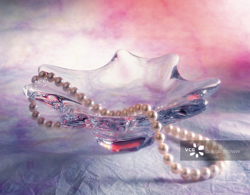 俯视玻璃盘上的珍珠项链图片素材