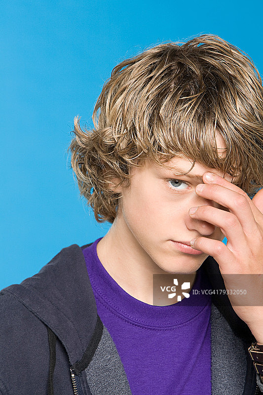 摸着脸的少年图片素材