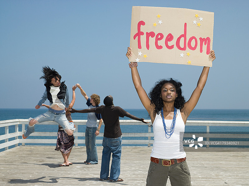女人举着“自由”标牌图片素材