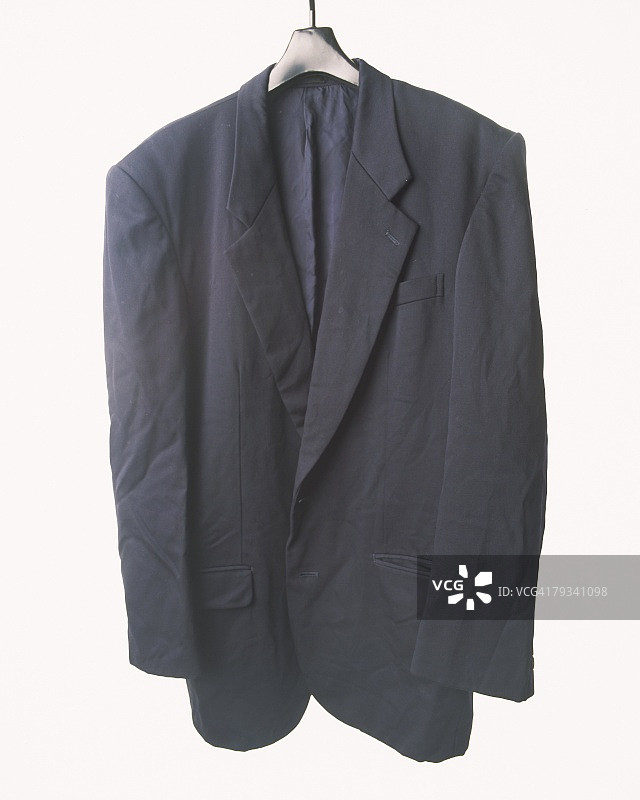 挂在白色墙上的褶皱西装图片素材