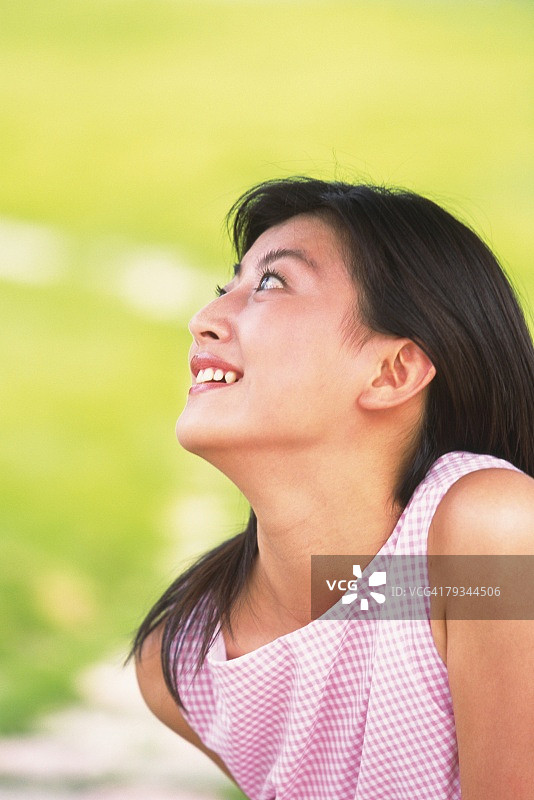 日本女人在绿色田野中仰望的侧脸图片素材