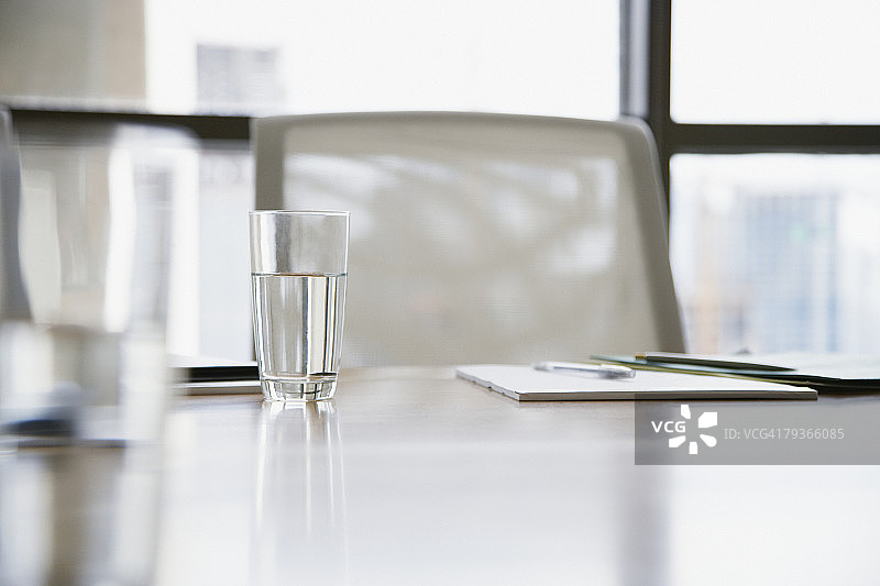 空荡荡的会议室，桌上放着笔记本和水杯图片素材