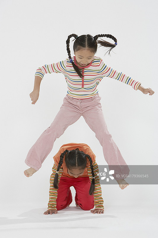 在室内跳山羊的年轻女孩们图片素材