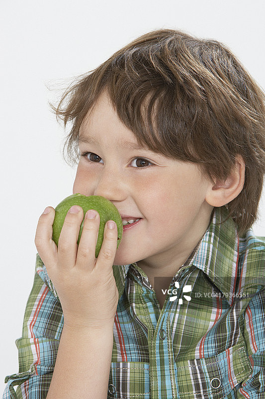 在室内吃苹果的小男孩图片素材